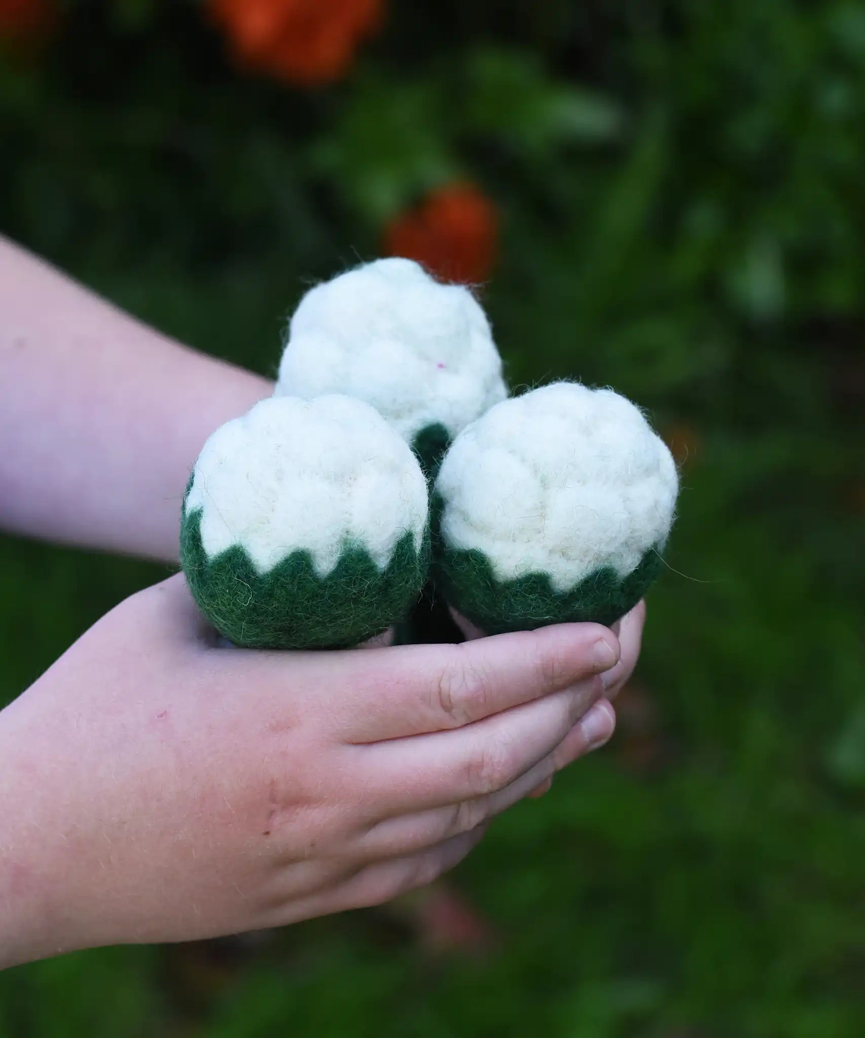 Papoose Toys felt cauliflower set of three in a child's hand.