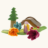 Papoose felted daffodil flowers used in a small world play scene with a wooden doll, tree and bridge in the background. 