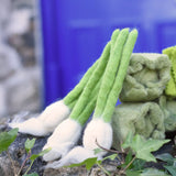 Papoose Toys feltgarlic set in a set of three placed on a stone wall outdoors.