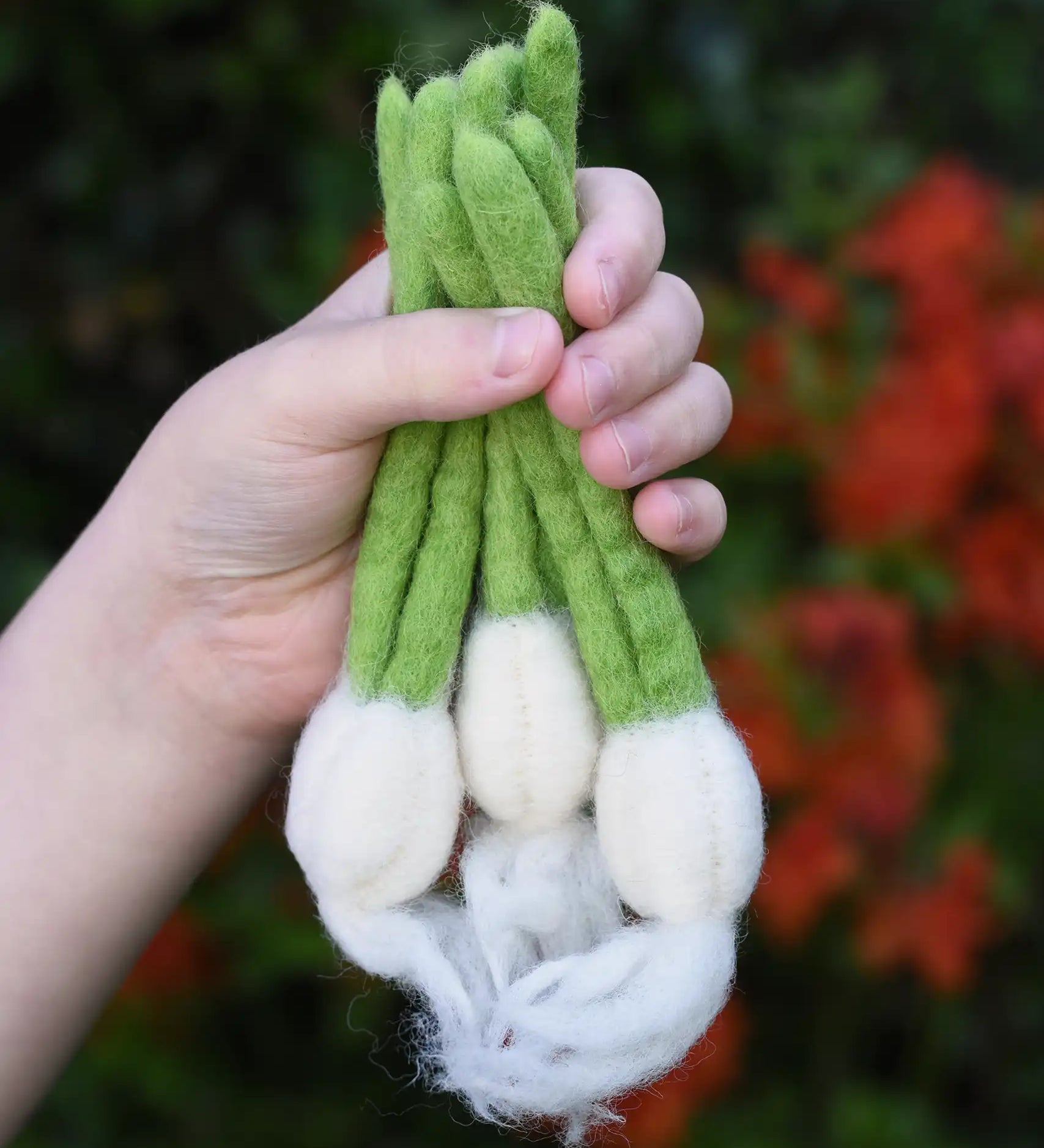 Papoose Toys felt garlic set in a set of three in a child's hand.