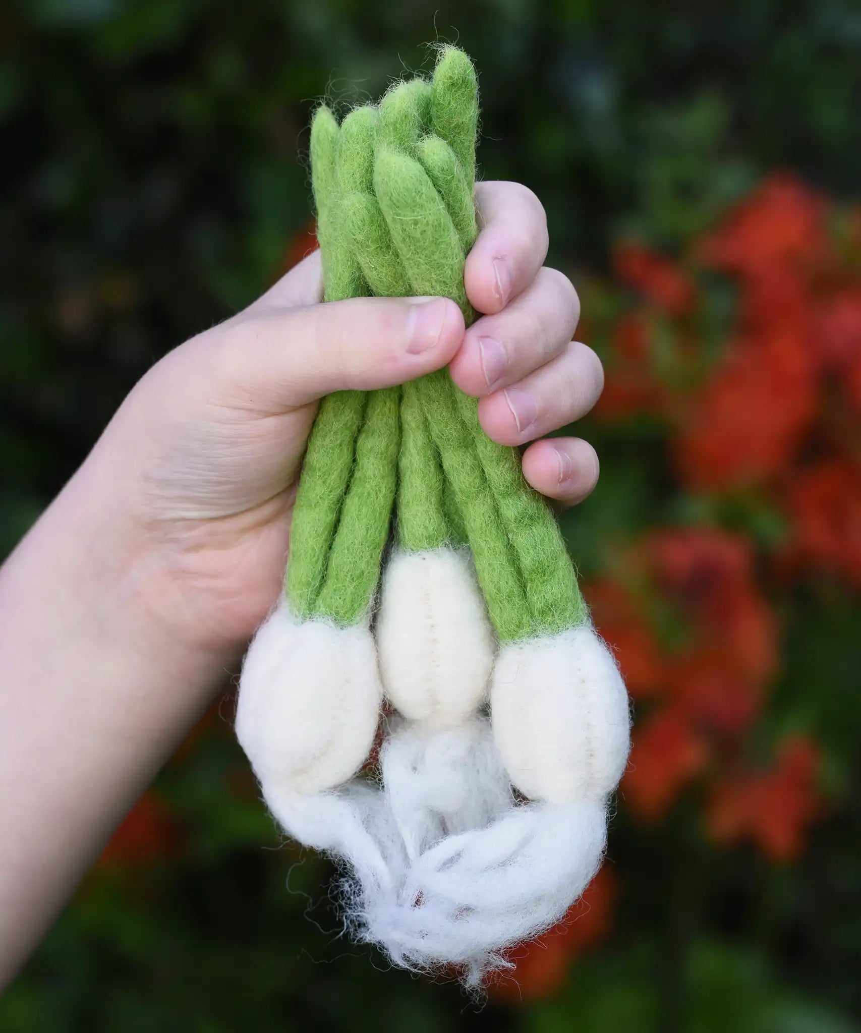 Papoose Toys felt garlic set in a set of three in a child's hand.