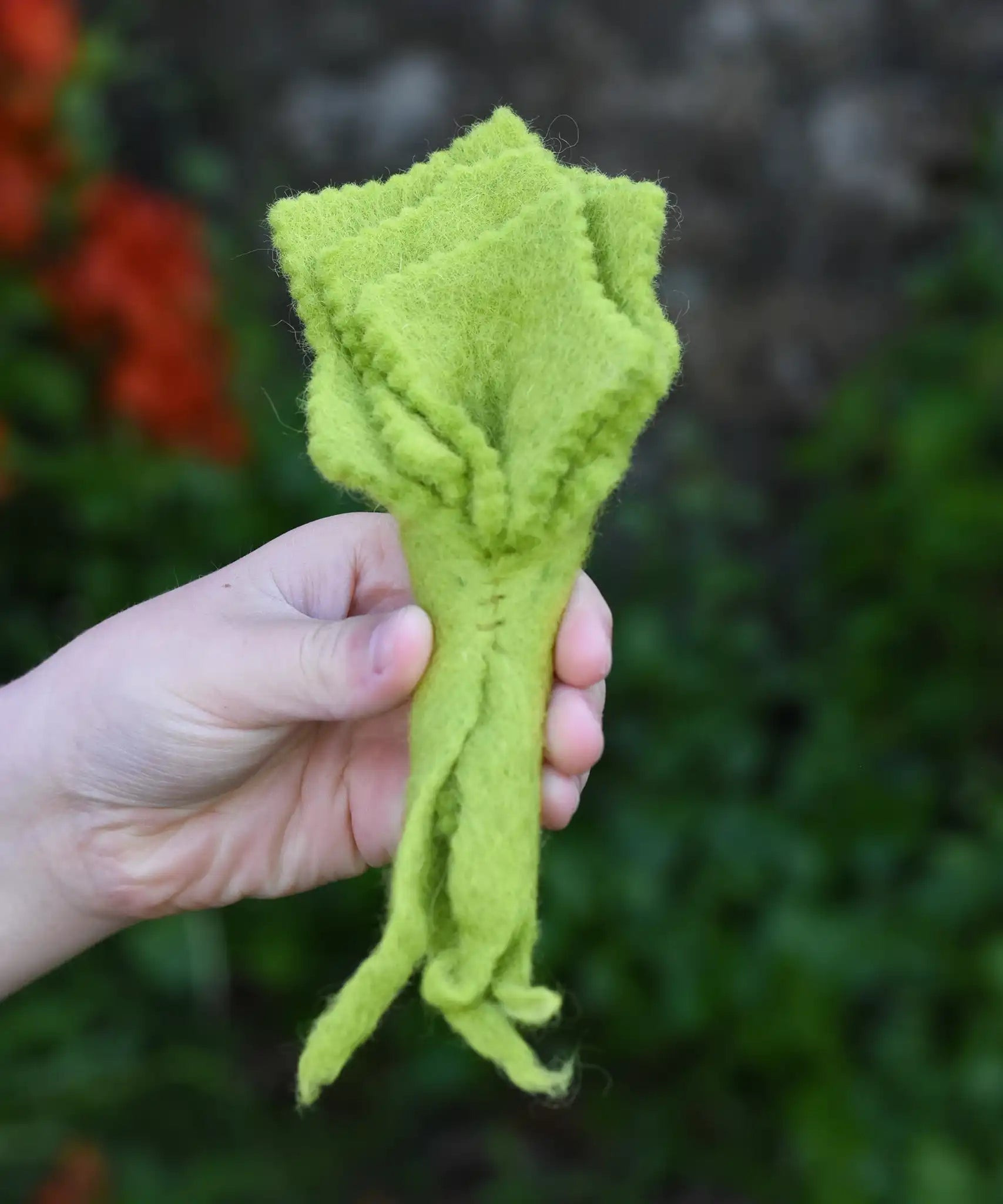 Papoose Toys felt lettuce in a child's hand.