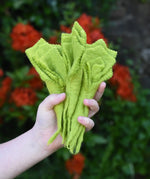 Papoose Toys felt lettuce set in a set of three in a child's hand.