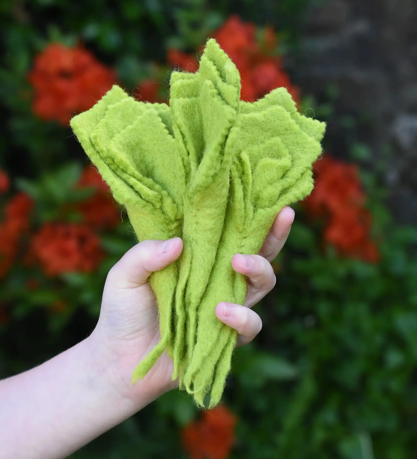 Papoose Toys felt lettuce set in a set of three in a child's hand.