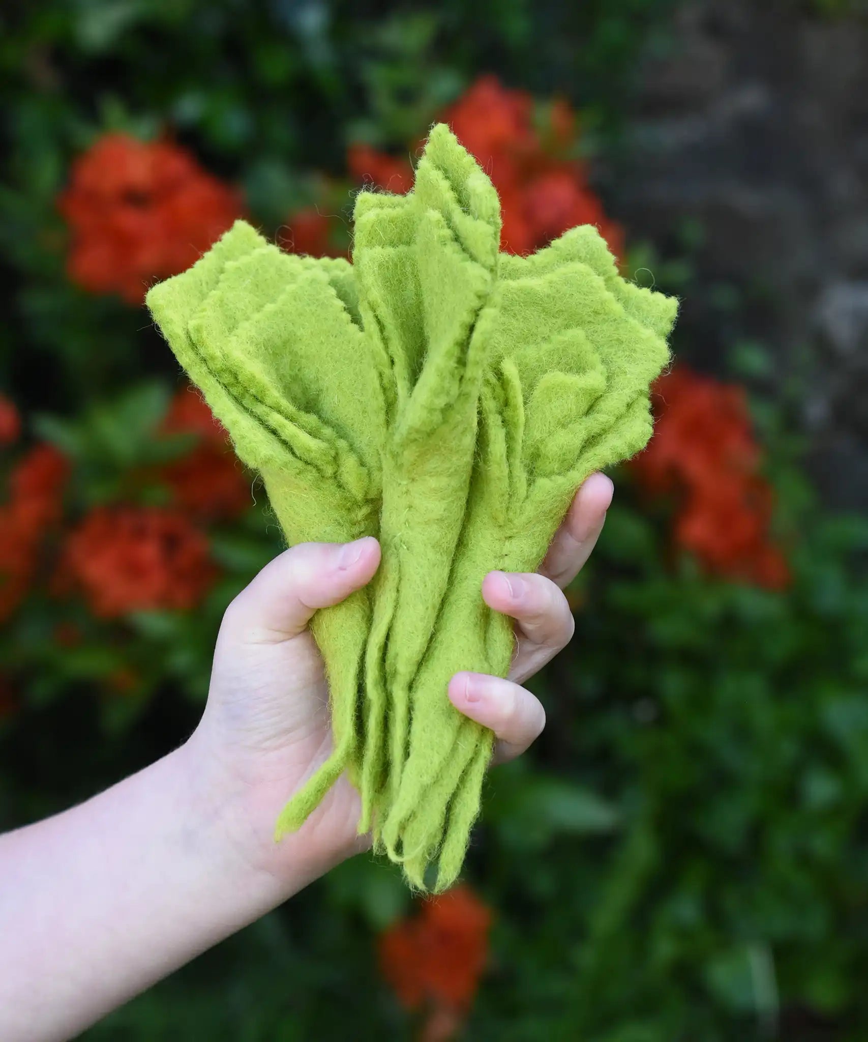 Papoose Toys felt lettuce set in a set of three in a child's hand.