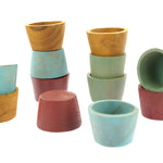 Stacks of the Papoose handmade small earth bowls on a white background