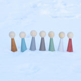 The Papoose Toys Wooden Earth colours People peg dolls placed on a snow covered surface outoors.
