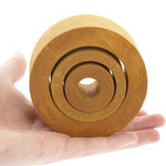 Close up of a hand holding the Papoose solid wooden nesting tube toys on a white background