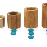 Papoose stacking wooden tubes lined up in order of size next to some Grapat counters for learning number play