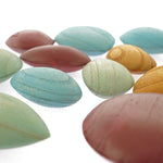 Close up of the Papoose childrens colourful earth pebble toys laid out on a white background