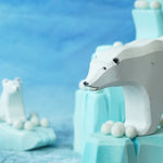 Felted white pom poms on wooden ice rock figures with wooden polar bear figures standing on the ice rocks.