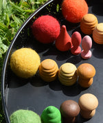 Close up of the Papoose felt balls placed in a mandala with Grapat mandala pieces. 