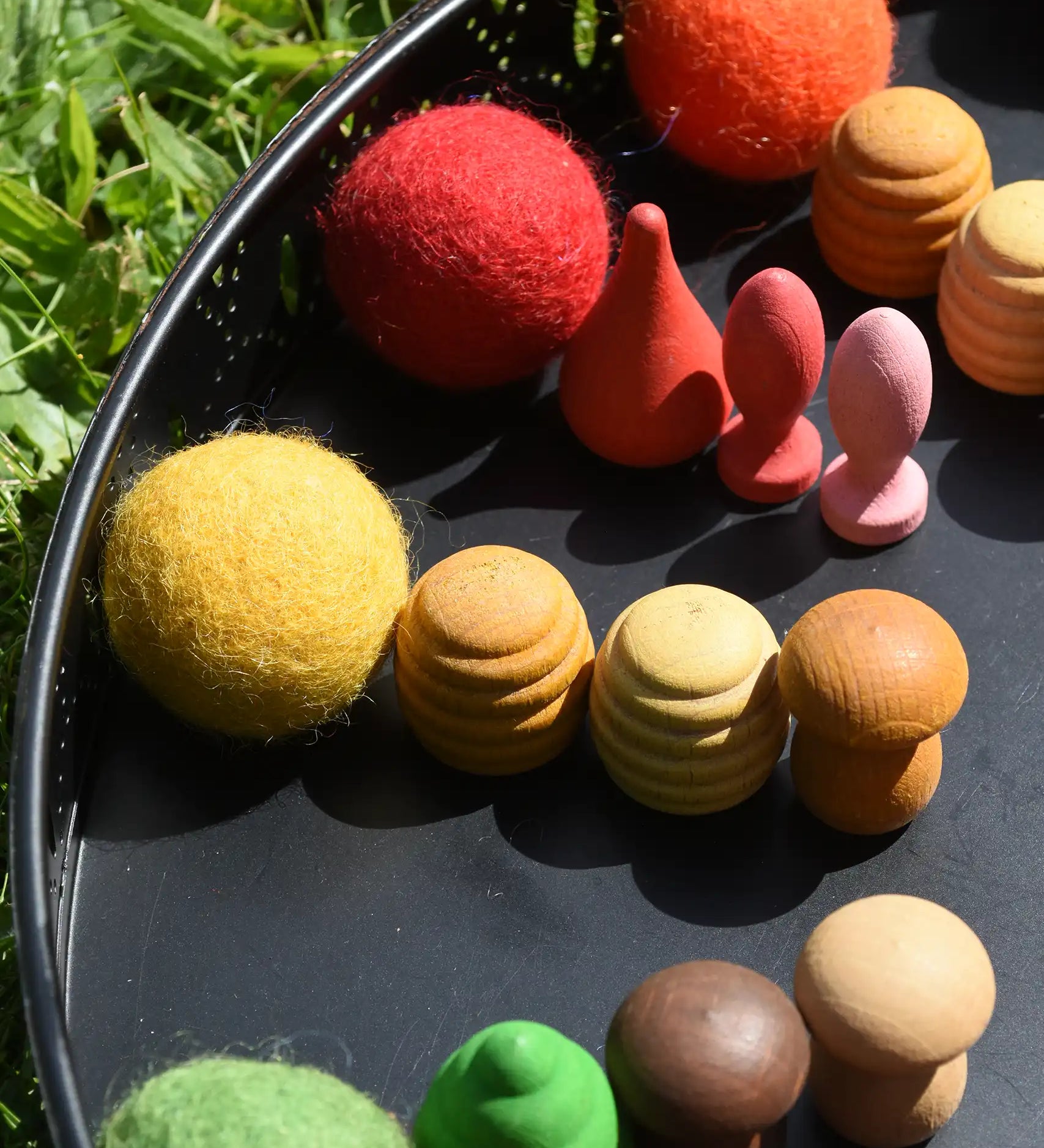 Close up of the Papoose felt balls placed in a mandala with Grapat mandala pieces. 