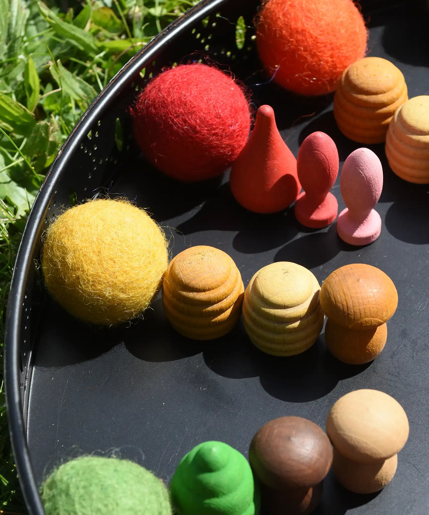Close up of the Papoose felt balls placed in a mandala with Grapat mandala pieces. 