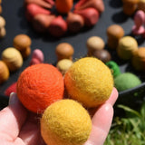 Close up of the Papoose felt balls in an adult's hands.