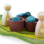 Papoose wooden bowls filled with Grapat wooden counters next to some Peepul wooden peg dolls