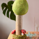 Papoose Toys Spring felt woodland tree placed on a rattan top stool. 