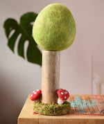 Papoose Toys Spring felt woodland tree placed on a rattan top stool. 