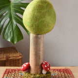 Papoose Toys Spring felt woodland tree placed on a rattan top stool. 