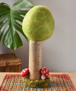 Papoose Toys Spring felt woodland tree placed on a rattan top stool. 
