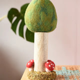Papoose Toys Summer felt woodland tree placed on a rattan top stool. 