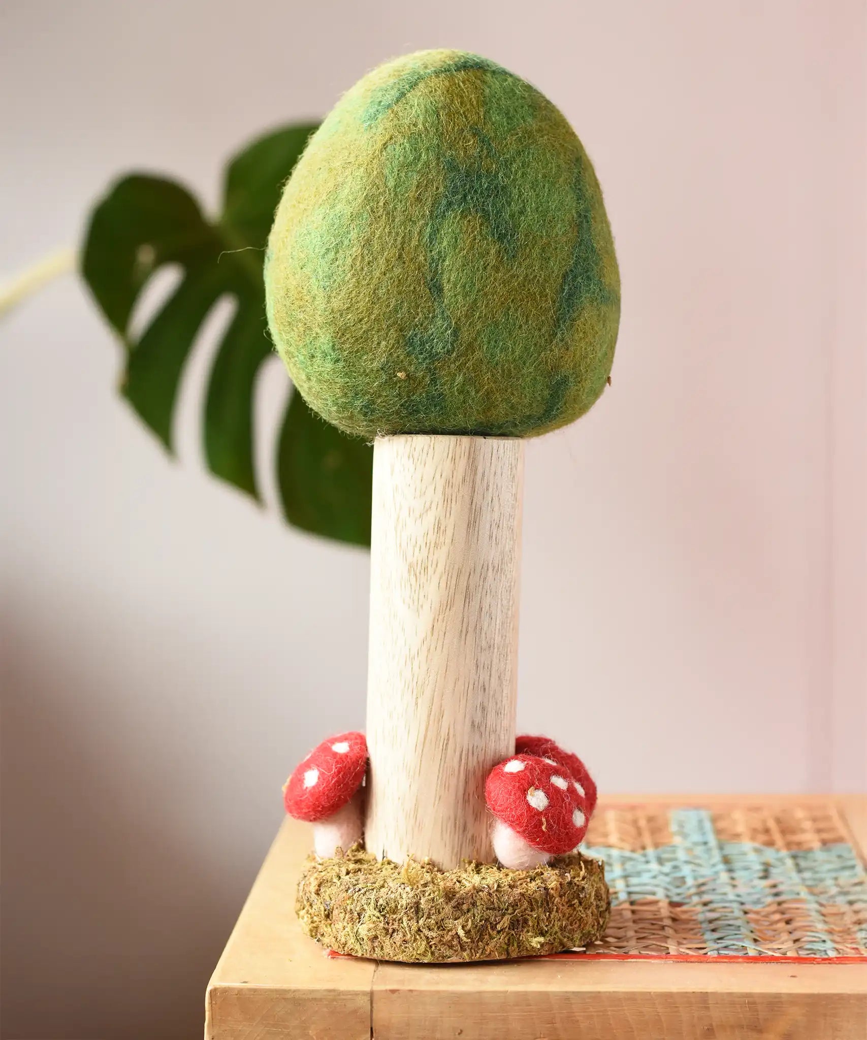 Papoose Toys Summer felt woodland tree placed on a rattan top stool. 