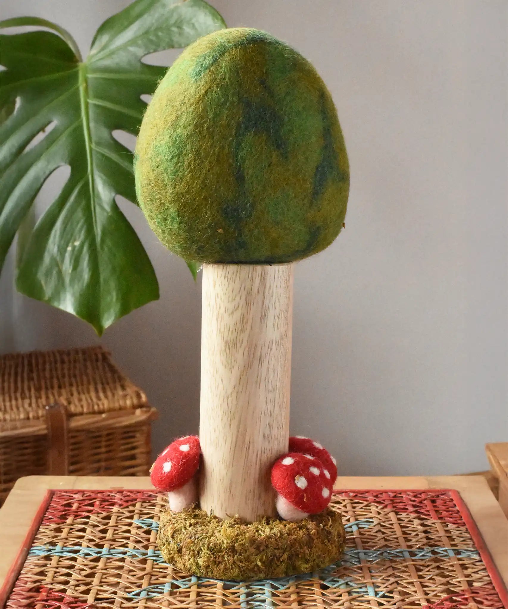 Papoose Toys Summer felt woodland tree placed on a rattan top stool. 