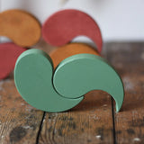 Papoose Toys wooden earth yim yams in green on a wooden desk. 