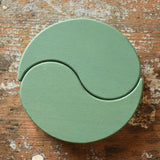 Papoose Toys wooden earth yim yams in green on a wooden desk. 