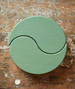 Papoose Toys wooden earth yim yams in green on a wooden desk. 