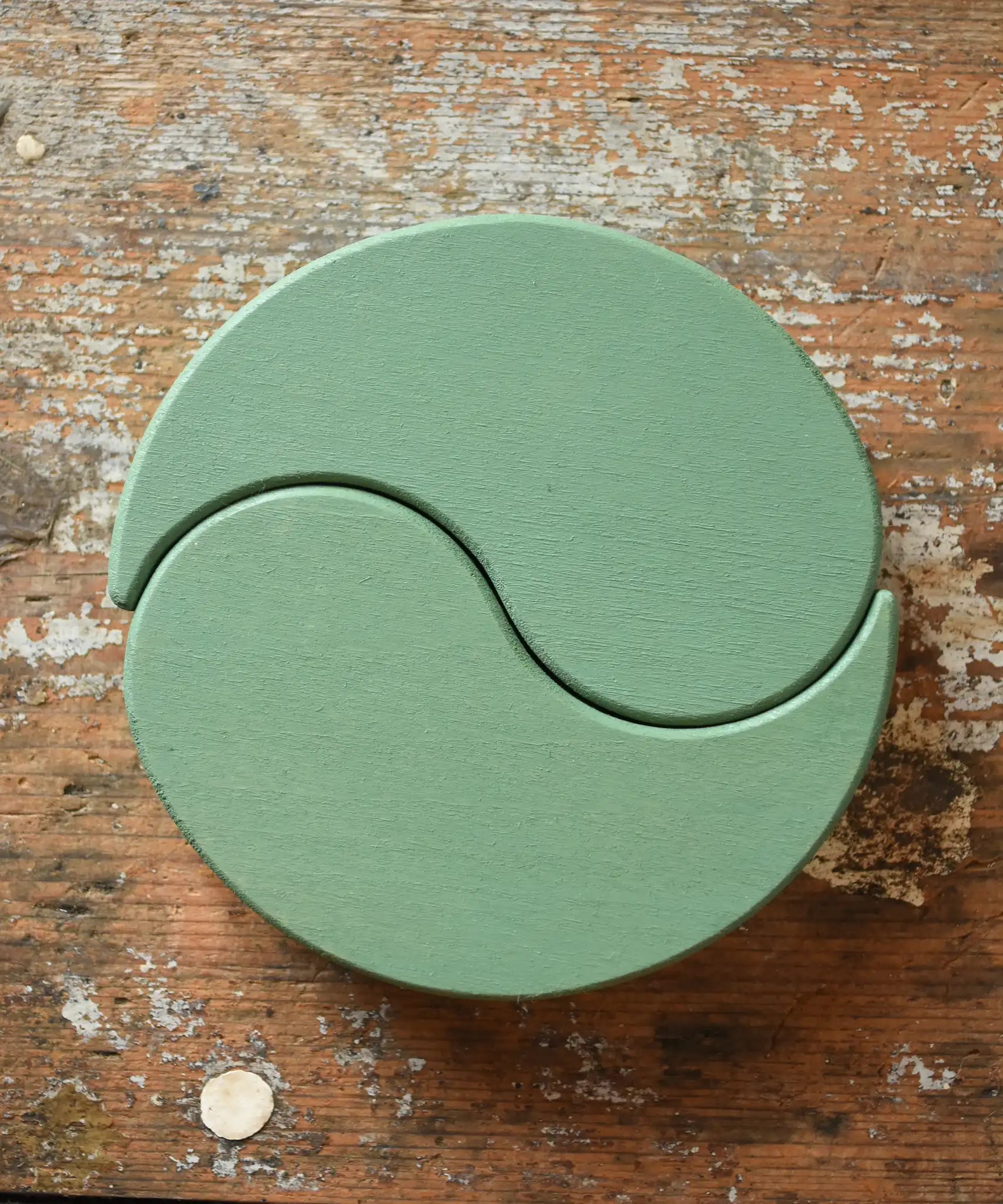 Papoose Toys wooden earth yim yams in green on a wooden desk. 