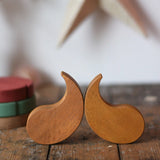 Papoose Toys wooden earth yim yam in yellow placed on a wooden desk.