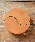 Papoose Toys wooden earth yim yam in yellow placed on a wooden desk.