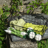 Papoose Toys felt vegetable play food placed in a black wire basket.