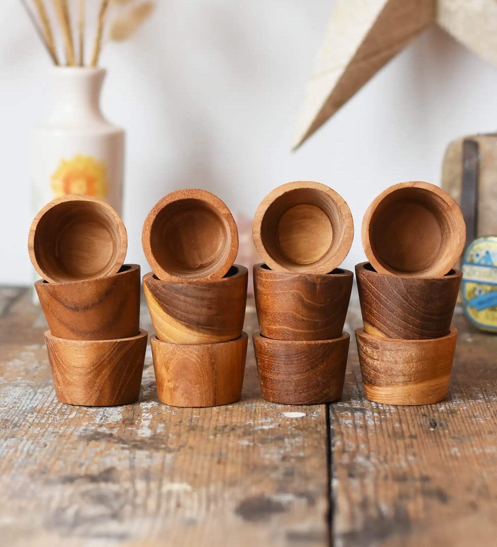 Papoose Toys 12 small natural wooden bowls placed on a wooden desk. 