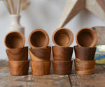 Papoose Toys 12 small natural wooden bowls placed on a wooden desk. 
