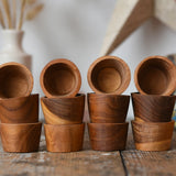 Papoose Toys 12 small natural wooden bowls placed on a wooden desk. 