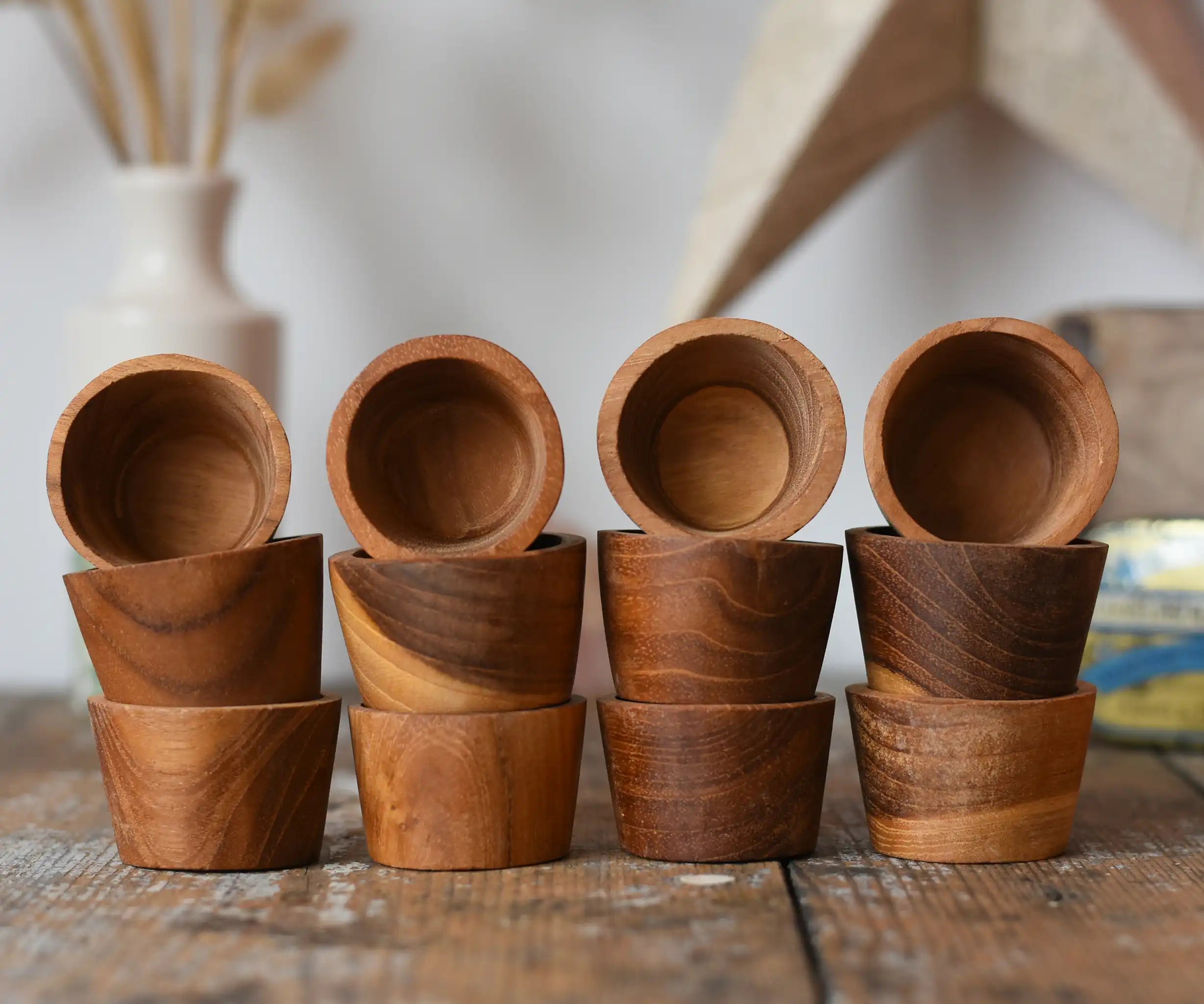 Papoose Toys 12 small natural wooden bowls placed on a wooden desk. 