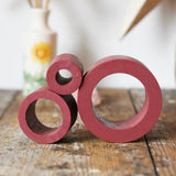 Papoose Toys nesting tubes in earth red on a wooden desk. 