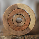 Papoose Toys nesting tubes natural wooden rings placed on a wooden desk. 