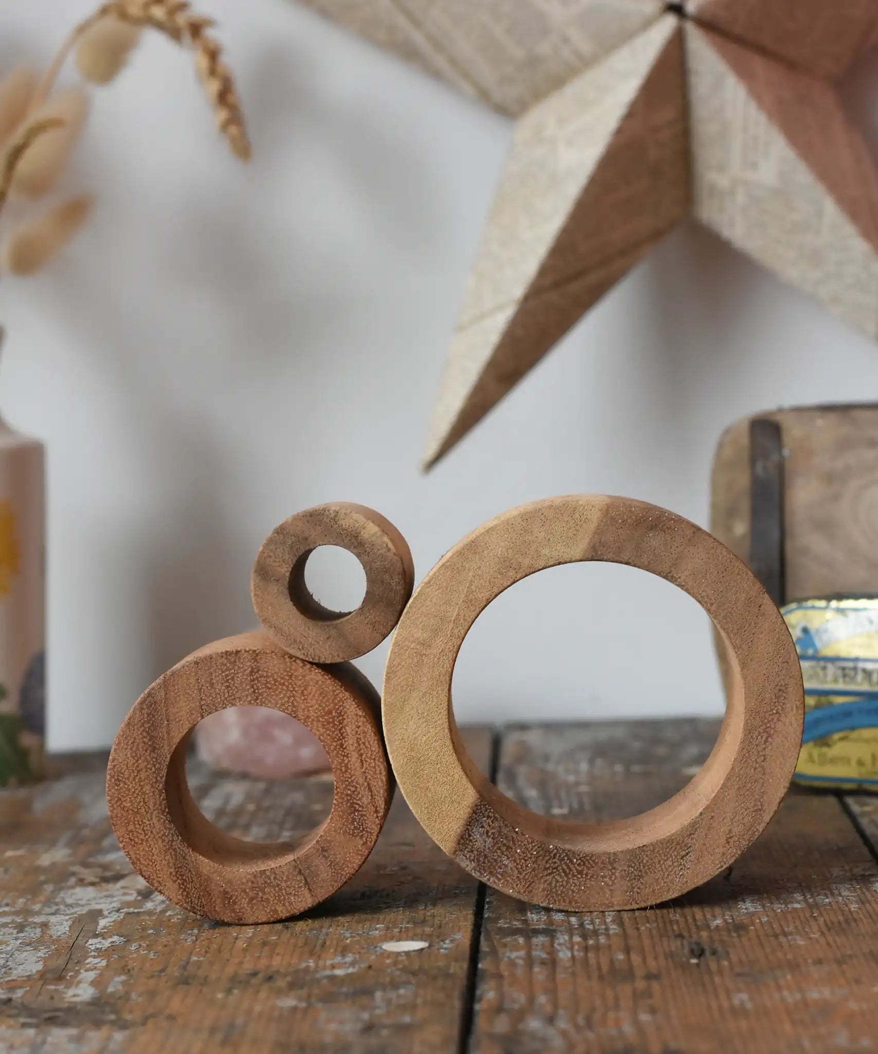 Papoose Toys nesting tubes natural wooden rings stacked on a wooden desk. 