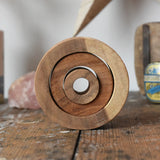 Papoose Toys nesting tubes natural wooden rings placed on a wooden desk. 