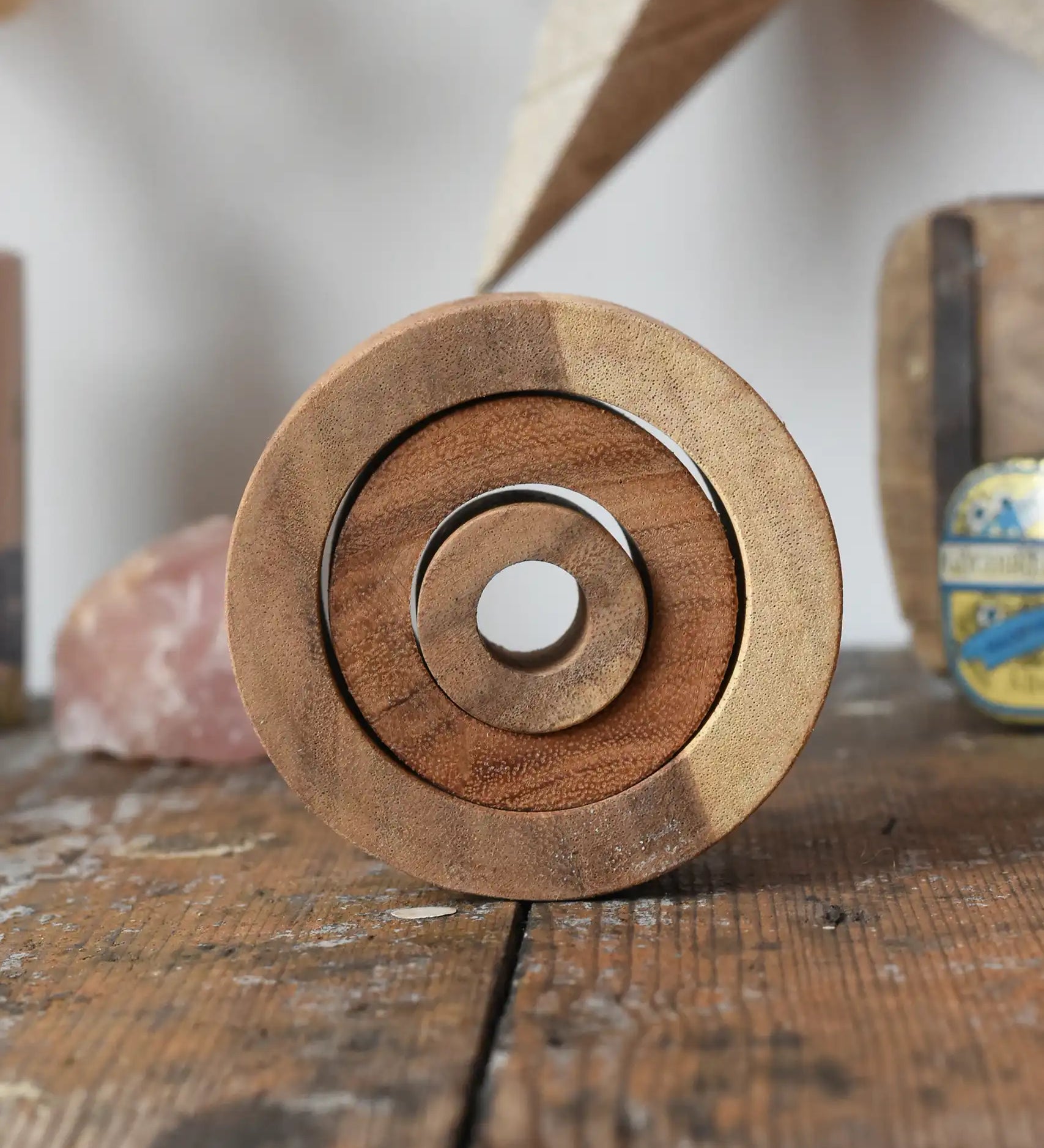 Papoose Toys nesting tubes natural wooden rings placed on a wooden desk. 
