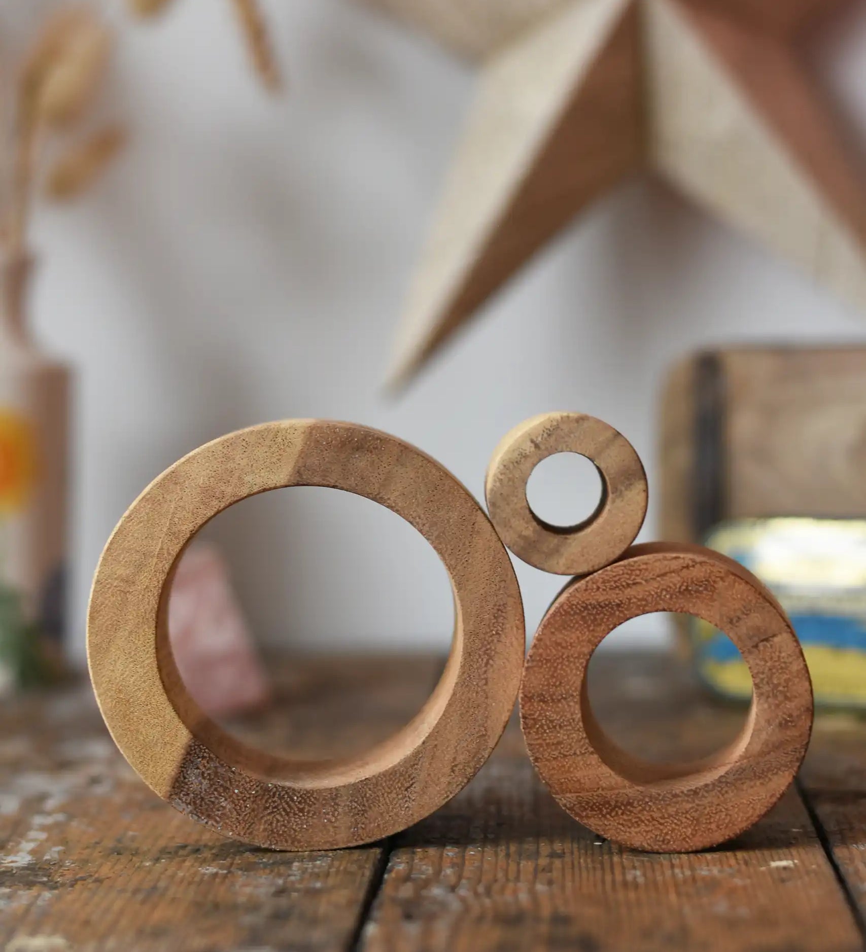 Papoose Toys nesting tubes natural wooden rings stacked on a wooden desk. 