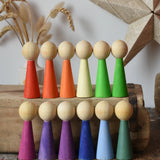 Papoose Toys 12 wooden Goethe rainbow people peg dolls placed on a wooden desk.