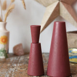 Papoose Toys wooden stacking cones in earth red placed on a wooden desk.