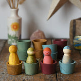 Papoose Toys wooden bowls in earth colours with Grapat Wild Crew peg dolls placed inside.