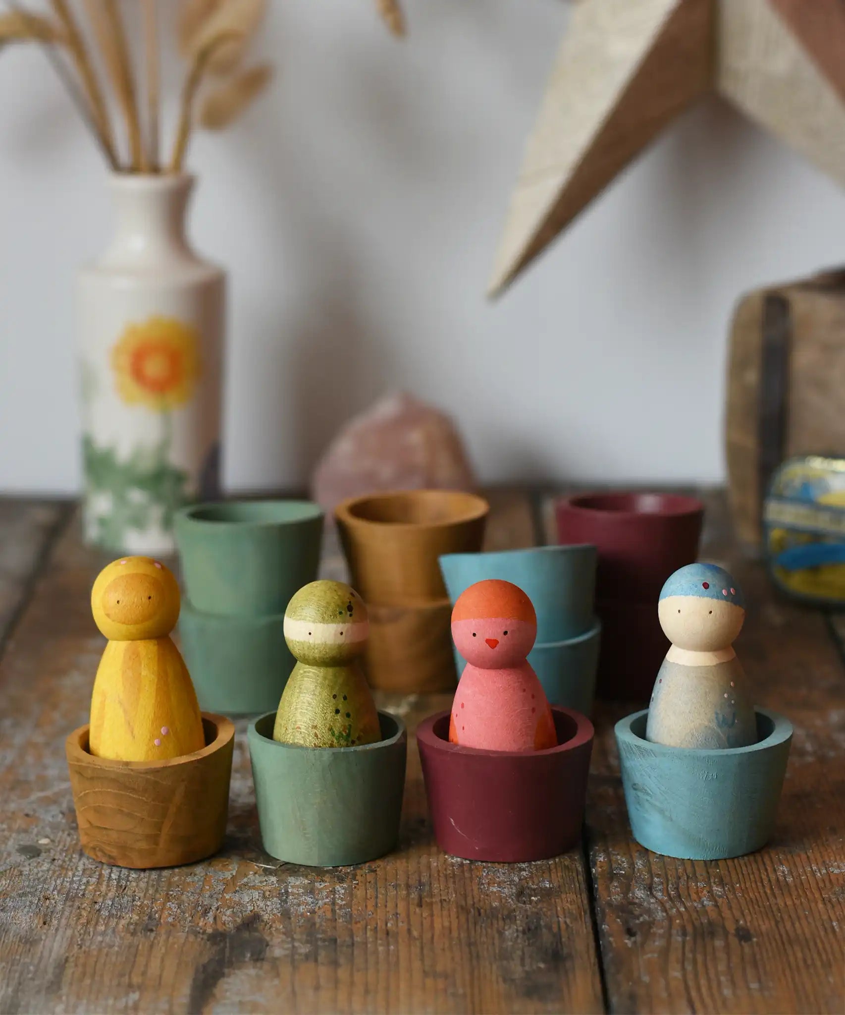 Papoose Toys wooden bowls in earth colours with Grapat Wild Crew peg dolls placed inside.