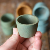Green Papoose Toys wooden bowl in an adult's hand.