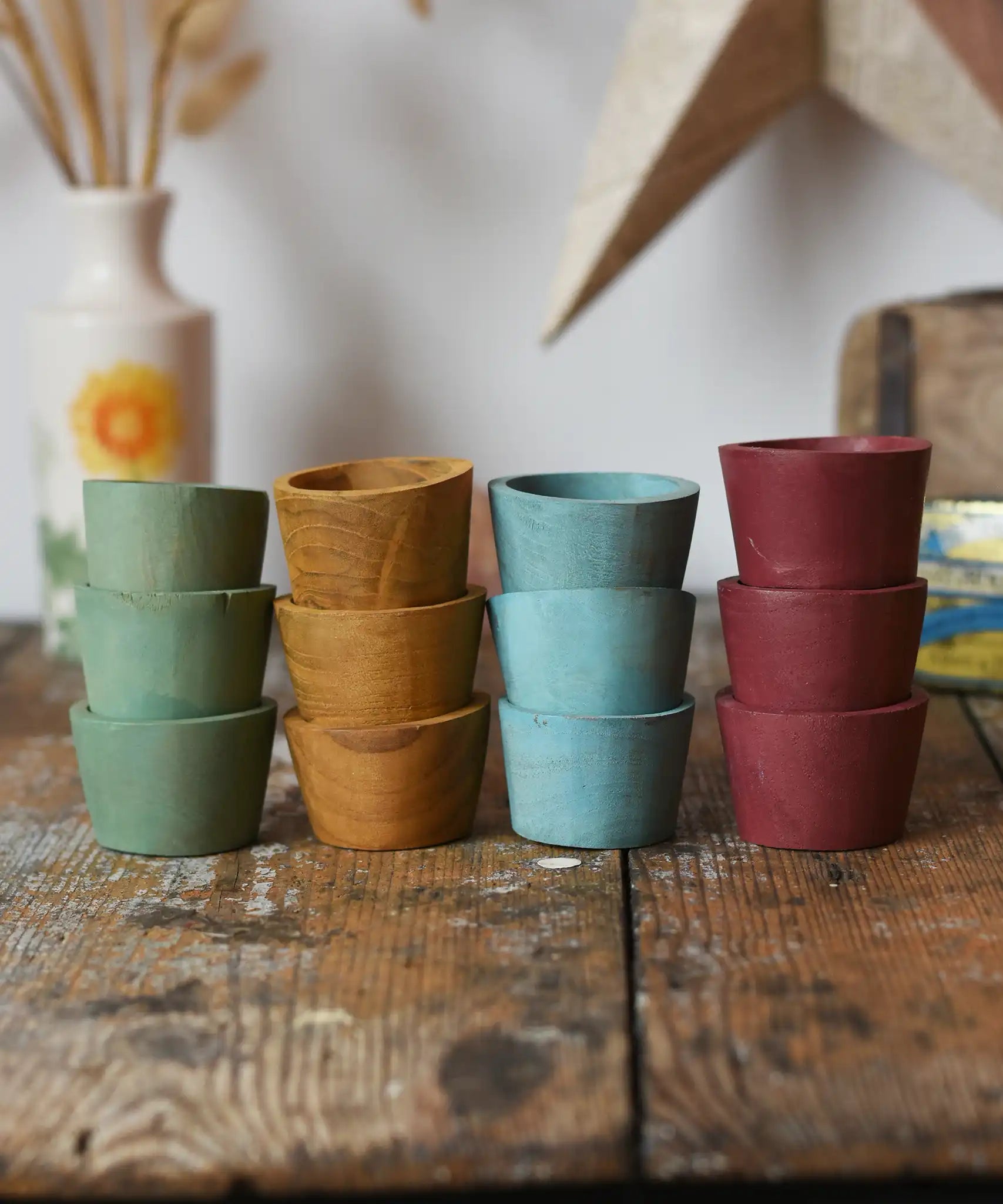 Papoose Toys wooden bowls in earth colours stacked up on a wooden desk.